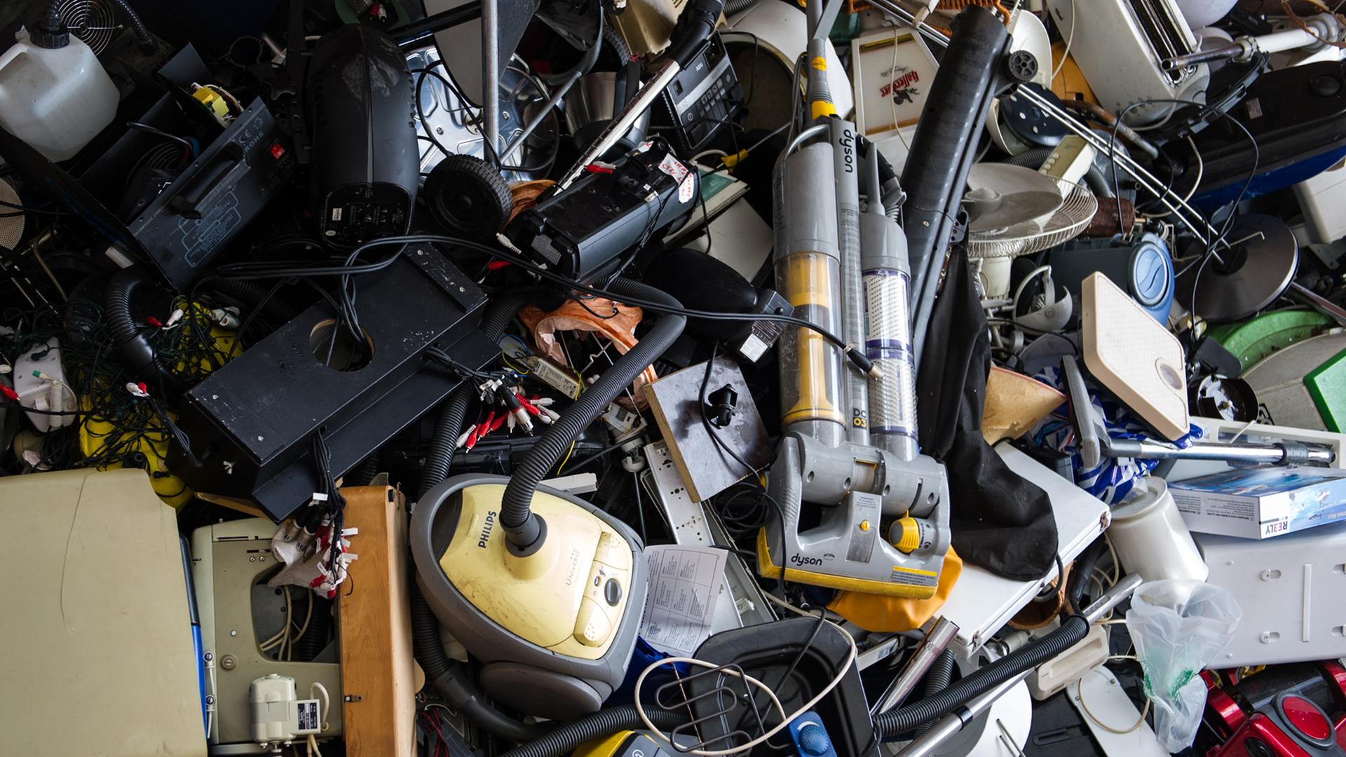 Ein Haufen Elektrogeräte, darunter Staubsauger und Werkzeug. Ein Haufen Elektrogeräte, darunter Staubsauger und Werkzeug.