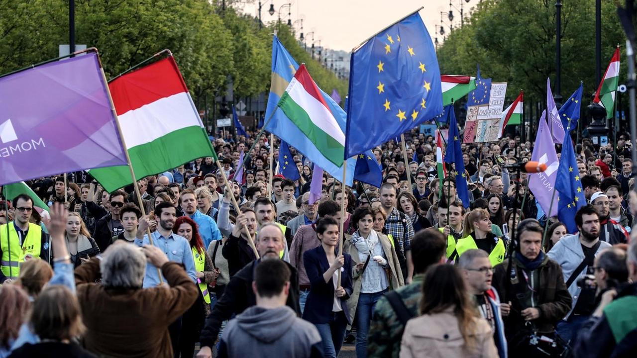 Demonstranten schwenken ungarische und europäische Fahnen. Demonstranten schwenken ungarische und europäische Fahnen.