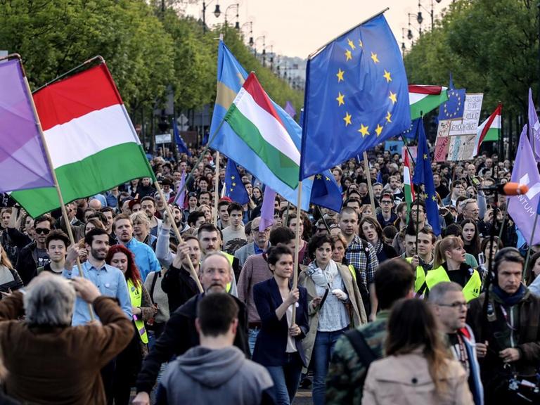 Demonstranten schwenken ungarische und europäische Fahnen.