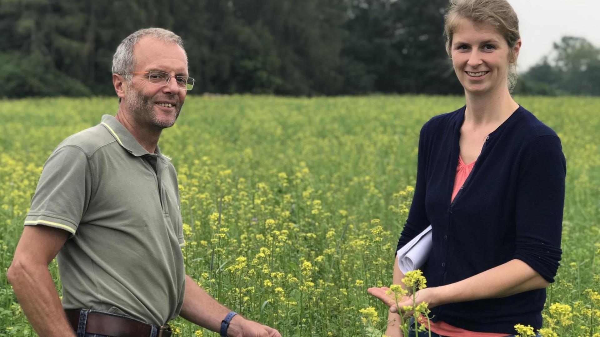 Die Landwirtin Cornelia Briem-Grooten steht zusammen mit dem Berater Georg Milz von der Landwirtschaftskammer NRW in einem blühenden Feld. Die Landwirtin Cornelia Briem-Grooten steht zusammen mit dem Berater Georg Milz von der Landwirtschaftskammer NRW in einem blühenden Feld.