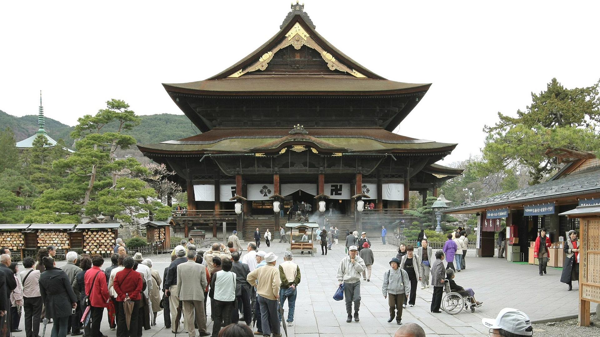 Menschen besuchen den buddhistischen Zenkoji-Tempel in der japanischen Stadt Nagano. Menschen besuchen den buddhistischen Zenkoji-Tempel in der japanischen Stadt Nagano.