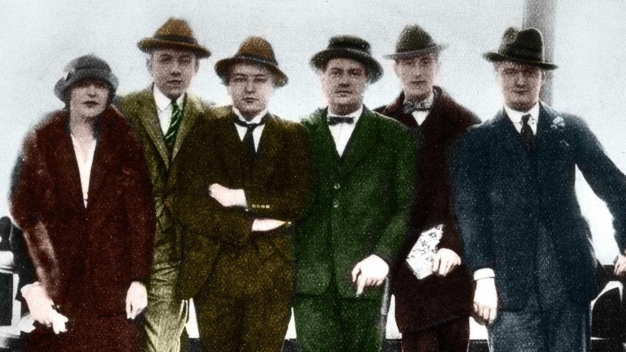 Auf einem nachcoloriertem Foto sind eine Frau und fünf Männer mit Hüten der Zeit zu sehen.