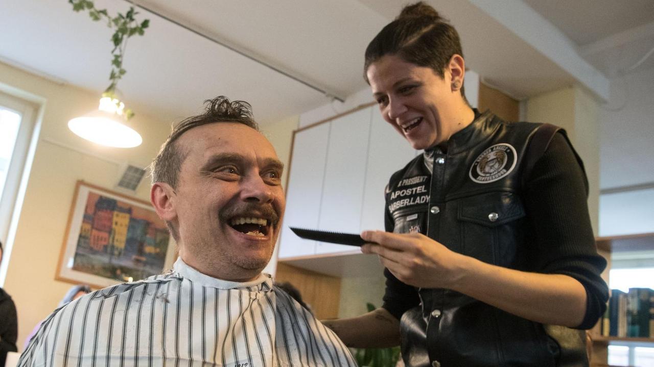 Ein Wohnungsloser bekommt während einer Haarschneideaktion der "Barber Angels Brotherhood" die Haare geschnitten.