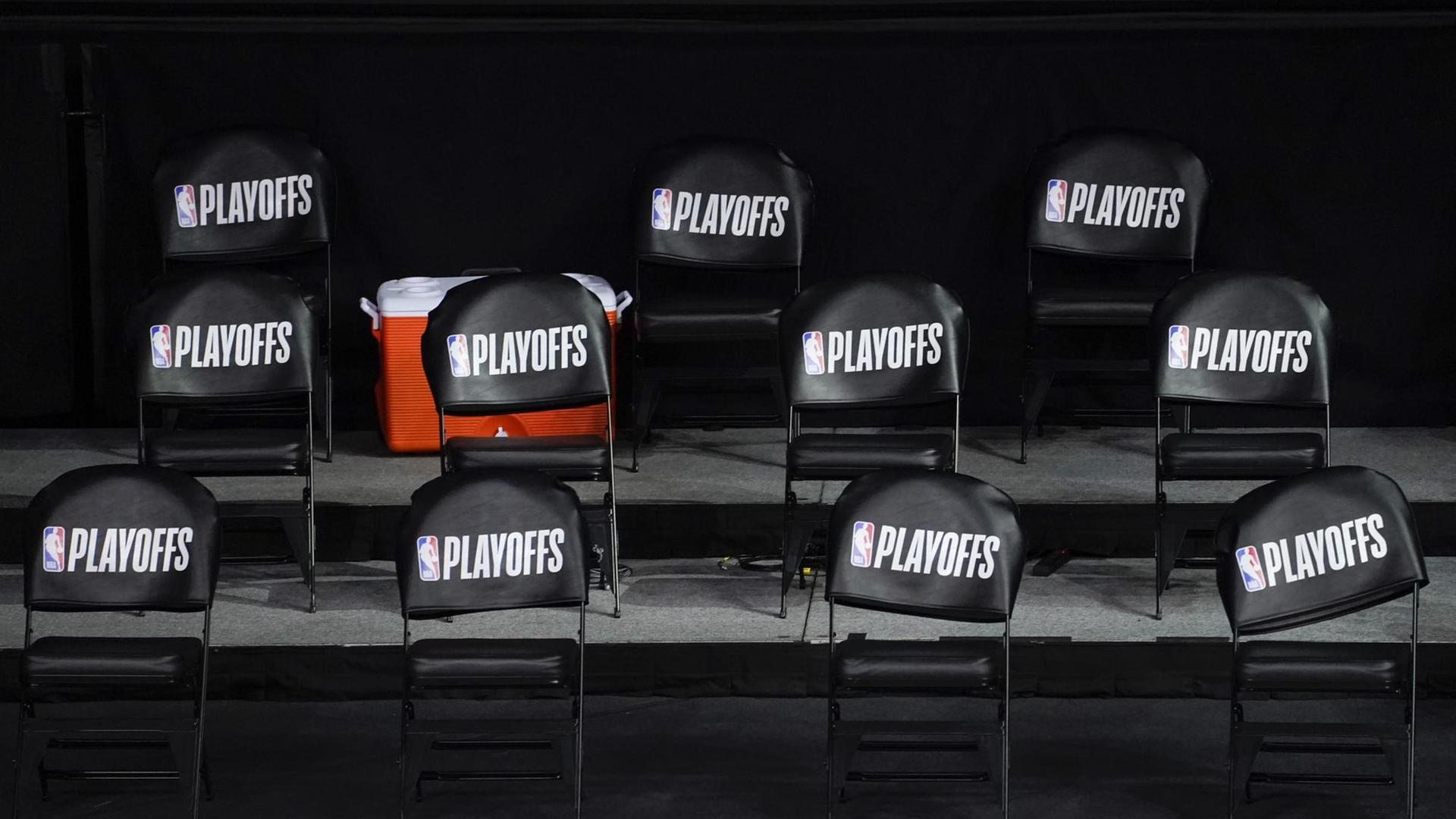 Leere Sitze stehen in der Baskeballhalle in Florida. Auf den Stühlen klebt ein Schild mit den Wort "Playoffs". Leere Sitze stehen in der Baskeballhalle in Florida. Auf den Stühlen klebt ein Schild mit den Wort "Playoffs".