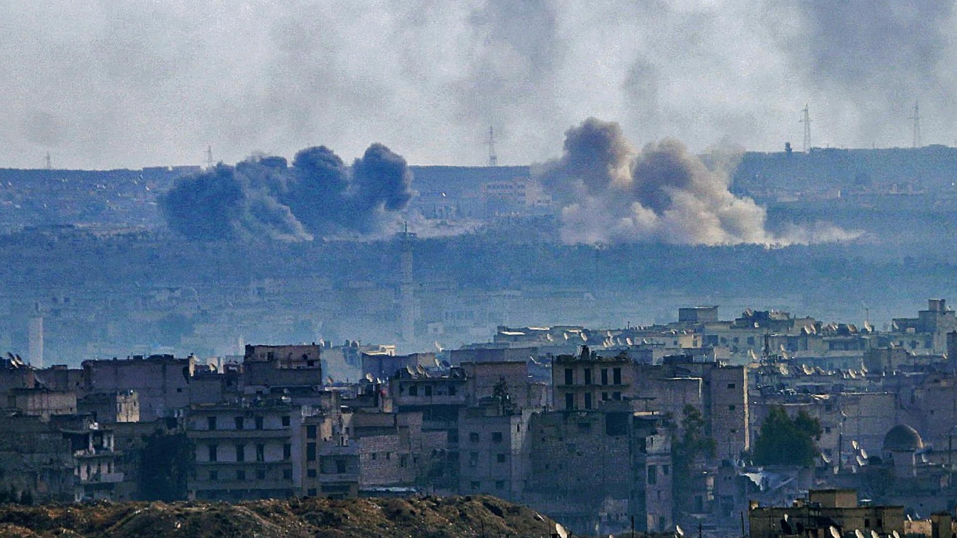 Sie sehen einen Blick auf den Ostteil von Aleppo aus der Luft. Über den Häusern hängen mehrere Luftwolken. Sie sehen einen Blick auf den Ostteil von Aleppo aus der Luft. Über den Häusern hängen mehrere Luftwolken.