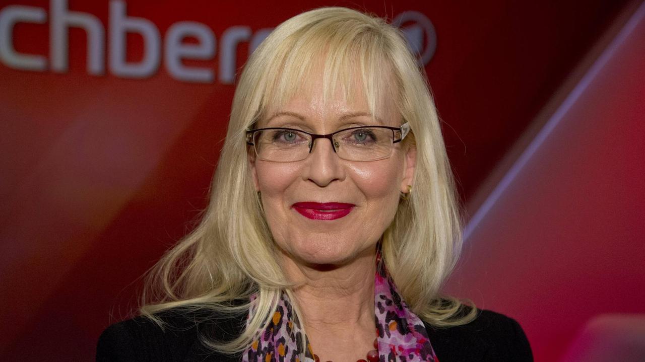 Susanne Schröter guckt vor einem dunkelroten Hintergrund lächelnd in die Kamera. Susanne Schröter guckt vor einem dunkelroten Hintergrund lächelnd in die Kamera.