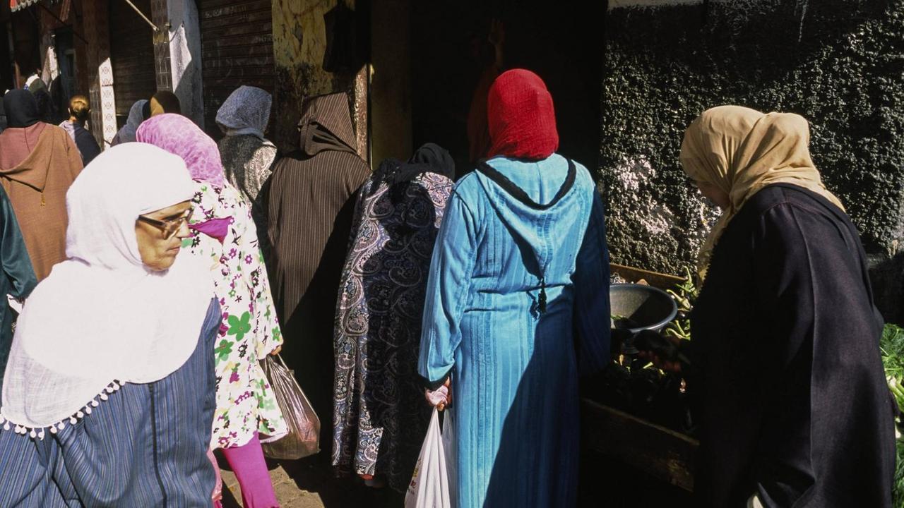 Frauen ziehen durch Altstadt von Casablanca und kaufen auf einem Strassenmarkt Lebensmittel ein. Frauen ziehen durch Altstadt von Casablanca und kaufen auf einem Strassenmarkt Lebensmittel ein.