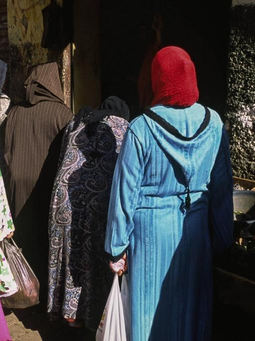 Frauen ziehen durch Altstadt von Casablanca und kaufen auf einem Strassenmarkt Lebensmittel ein.