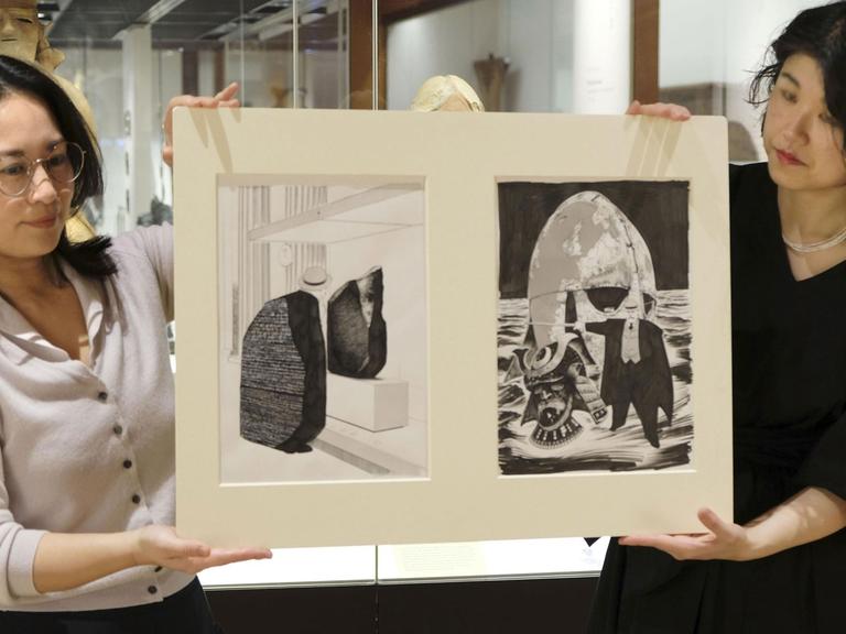 Auf dem Bild präsentieren zwei Japanerinnen Original-Zeichnungen aus der Manga-Serie "Munakata Kyouju" (Professor Munakata) von Yukinobu Hoshino im British Museum.