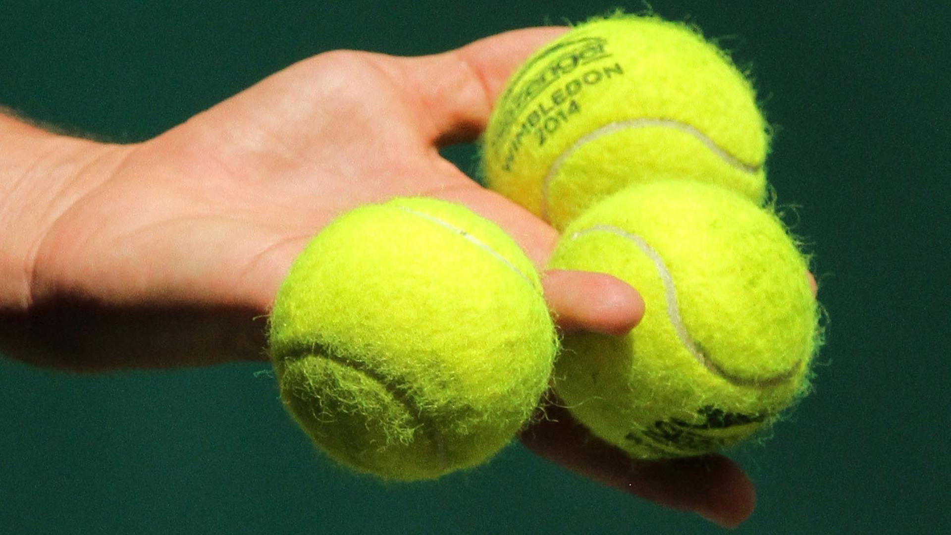Drei Tennisbälle in der Hand eines Spielers Drei Tennisbälle in der Hand eines Spielers