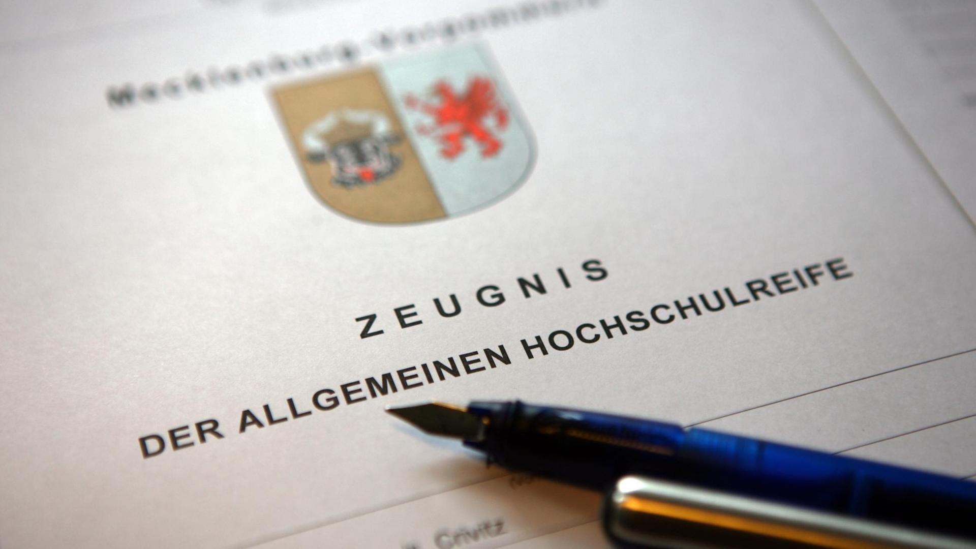 ILLUSTRATION - Ein Füllfederhalter liegt auf einem Abiturzeugnis des Landes Mecklenburg-Vorpommern. Foto: Jens Büttner/dpa | dpa-Zentralbild| Verwendung weltweit ILLUSTRATION - Ein Füllfederhalter liegt auf einem Abiturzeugnis des Landes Mecklenburg-Vorpommern. Foto: Jens Büttner/dpa | dpa-Zentralbild| Verwendung weltweit