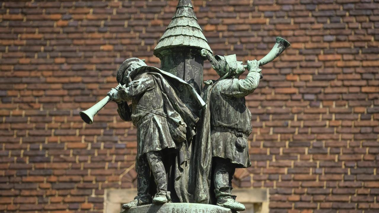 Bronzedenkmal mit Turm und darauf spielenden Musikern. Bronzedenkmal mit Turm und darauf spielenden Musikern.