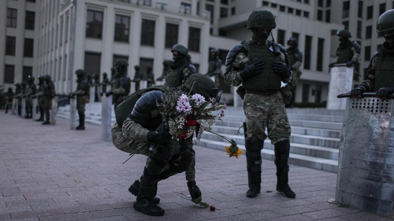 Polizisten heben Blumen auf.