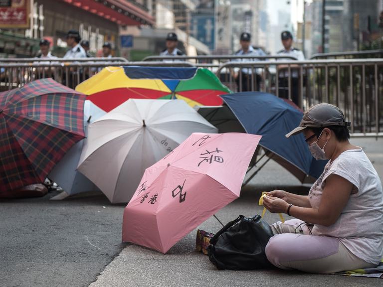 Mitglied der Occupy-Bewegung in Hongkong mit Regenschirmen
