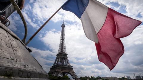 Die Flagge Frankreichs weht am Heck eines Schiffes vor dem Eiffelturm in Paris