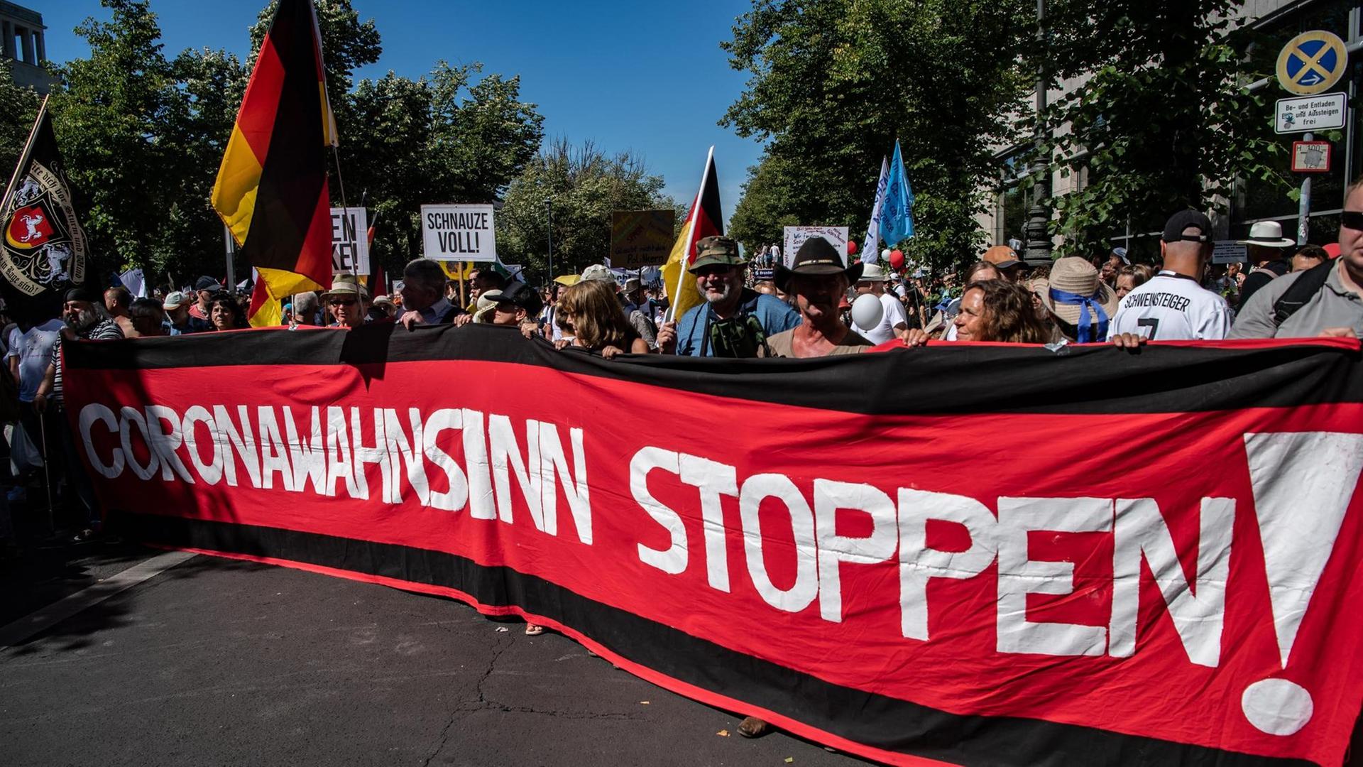 "Coronawahnsinn stoppen" steht auf einem Banner, das Teilnehmer auf der Demonstration gegen die Corona-Beschränkungen auf dem Boulevard Unter den Linden zeigen. "Coronawahnsinn stoppen" steht auf einem Banner, das Teilnehmer auf der Demonstration gegen die Corona-Beschränkungen auf dem Boulevard Unter den Linden zeigen.