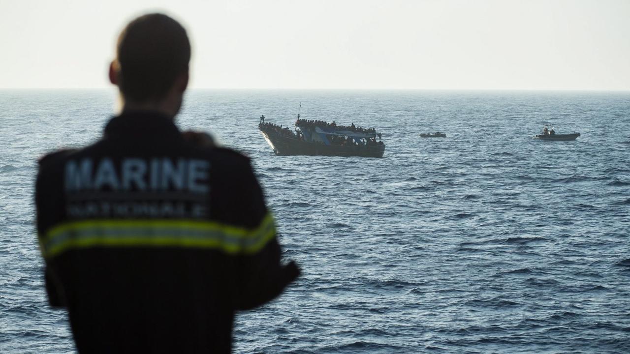 Ein Kommandeur der französischen Marine vor einem Boot mit Flüchtlingen während eines Frontex-Einsatz