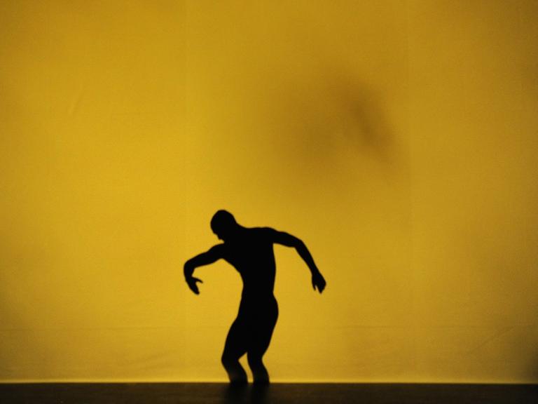 Modern Dance Performance: ein Mann vor einem großen gelben projektierten Fleck