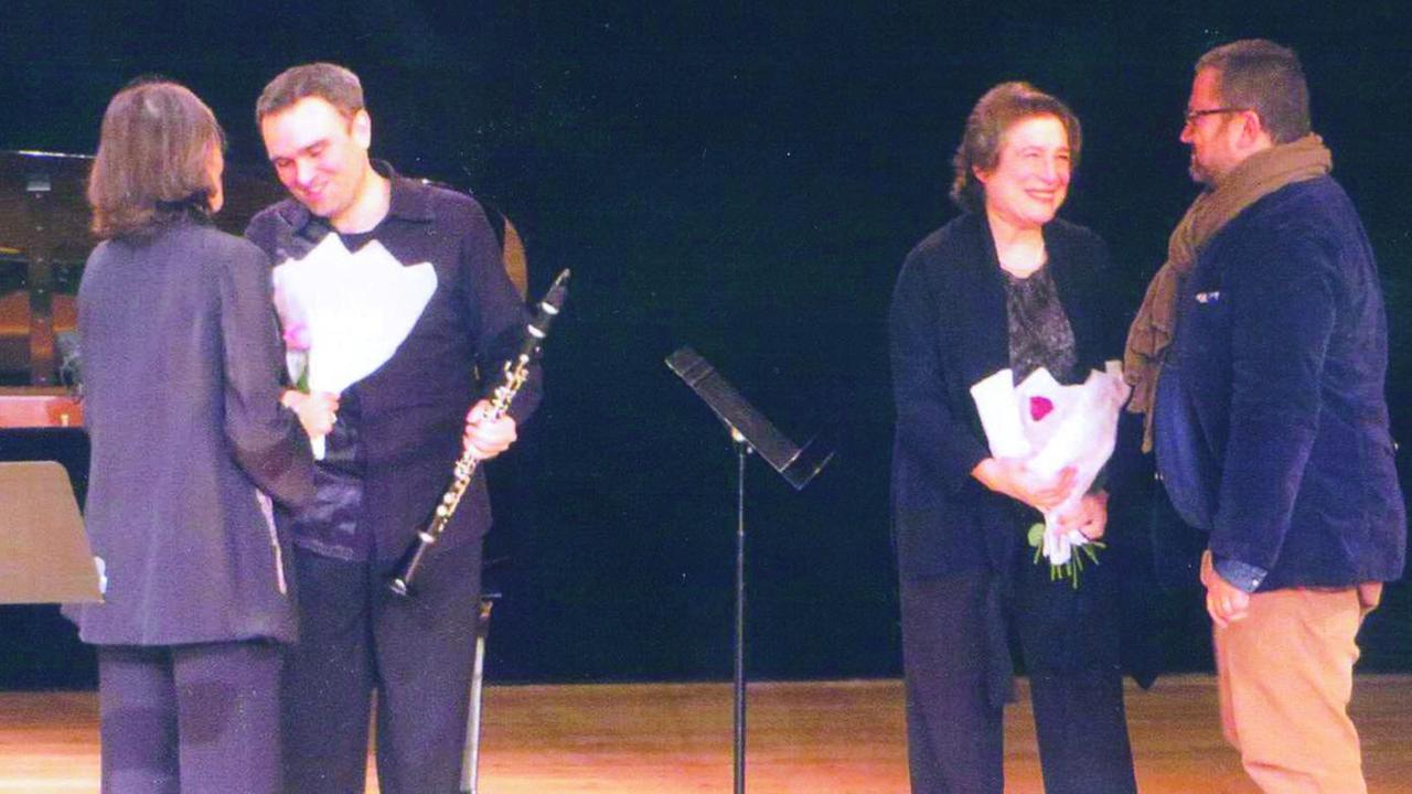 Ein Klarinettist und eine Pianistin erhalten Blumen auf der Bühne nach einem Auftritt. Ein Klarinettist und eine Pianistin erhalten Blumen auf der Bühne nach einem Auftritt.