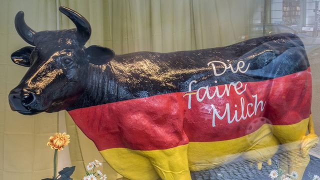 Rind aus Kunststoff mit den Deutschlandfarben angemalt und der Aufschrift: "Die faire Milch"