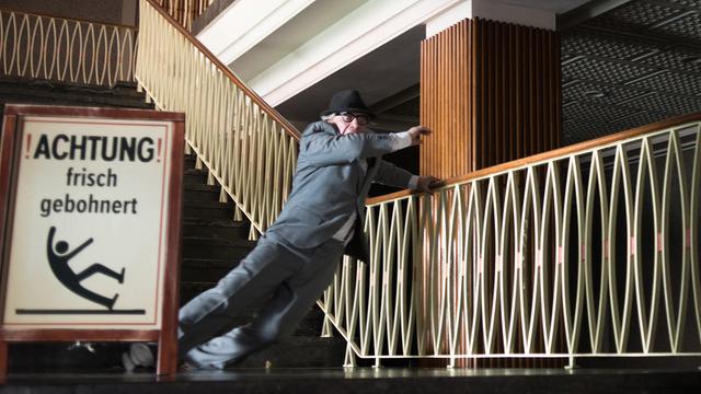 Szenenfoto: Jörg Schüttauf als Honecker rutscht auf der gebohnerten Treppe aus und kann sich gerade noch halten