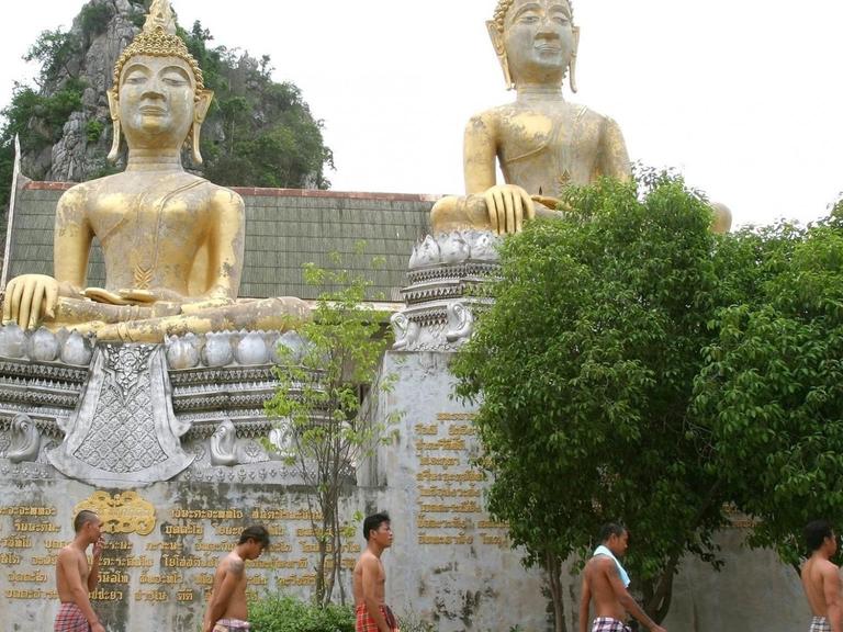 Drogenabhängige im buddhistischen Wat Thamkrabok Kloster auf dem Weg zu ihrem täglichen Kräuterdampfbad.