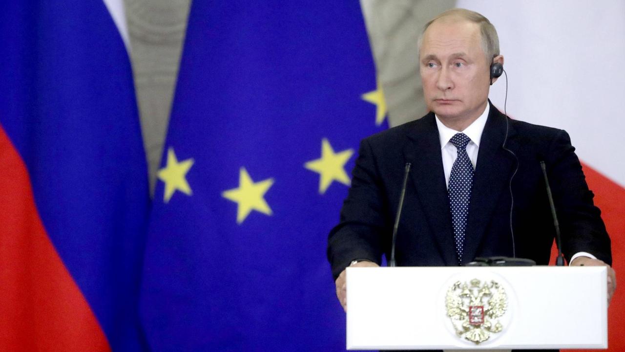 Der russische Präsident Wladimir Putin während einer Pressekonferenz vor einer EU-Flagge.