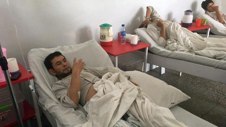 Blick in ein Patientenzimmer mit drei Patienten, die im Bett liegen, in Kabul, Afghanistan, in einem Krankenhaus.