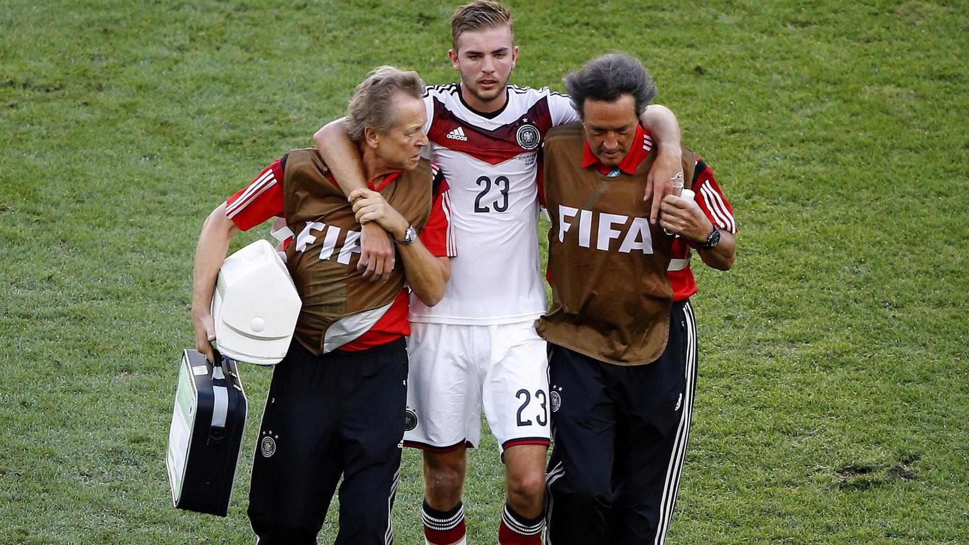 Der deutsche Fußball-Nationalspieler wird während des WM-Finales 2014 gegen Argentinien vom Platz geführt, nachdem er mit einem Gegenspieler zusammengestoßen war. Der deutsche Fußball-Nationalspieler wird während des WM-Finales 2014 gegen Argentinien vom Platz geführt, nachdem er mit einem Gegenspieler zusammengestoßen war.