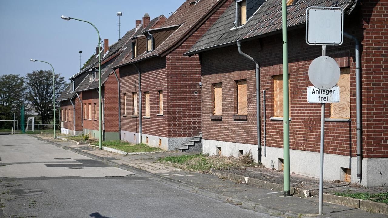 Eine Straßenzeile mit Häusern in Morschenich, deren Fenster mit Holzbrettern vernagelt sind. Eine Straßenzeile mit Häusern in Morschenich, deren Fenster mit Holzbrettern vernagelt sind.
