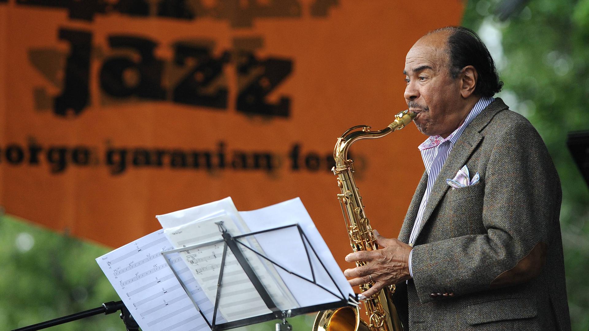 Benny Golson steht auf einer Bühne und spielt Saxophon Benny Golson steht auf einer Bühne und spielt Saxophon