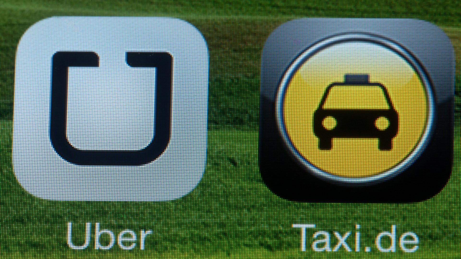 Die Handy-App "Uber" auf einem Smartphone neben dem Logo der Taxi-Vermittlung, Aufnahme vom September 2014 Die Handy-App "Uber" auf einem Smartphone neben dem Logo der Taxi-Vermittlung, Aufnahme vom September 2014