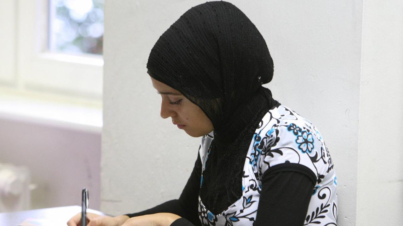 Muslimische Schülerin schreibt beim Unterricht an einer Berliner Gesamtschule mit.