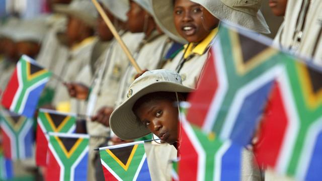 Südafrikanische Kinder (mit Flaggen) vor dem Parlamentsgebäude in Kapstadt.