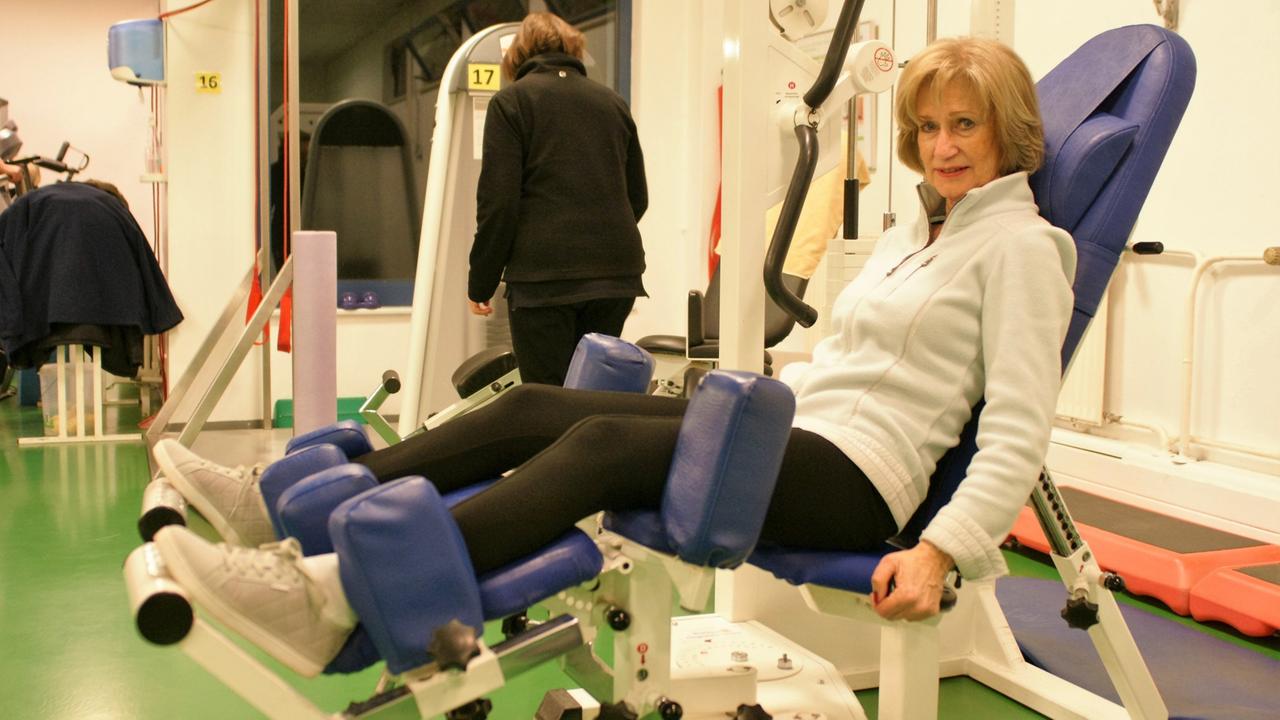 Eine Seniorin auf einem Gerät fürs Krafttraining Eine Seniorin auf einem Gerät fürs Krafttraining