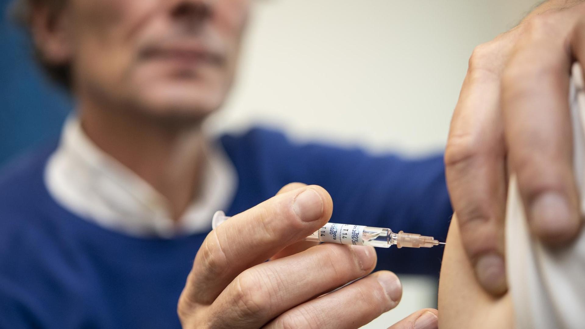 Ein Arzt impft am 13.11.2019 einen Patienten Ein Arzt impft am 13.11.2019 einen Patienten