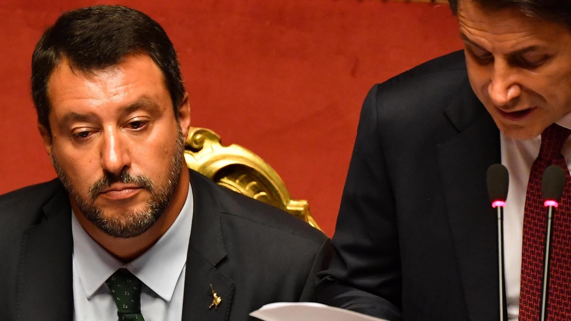 Italiens Ministerpräsident Giuseppe Conte (r.) bei einer Rede im Senat, neben ihm Innenminister Salvini Italiens Ministerpräsident Giuseppe Conte (r.) bei einer Rede im Senat, neben ihm Innenminister Salvini