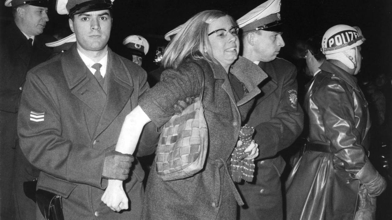 Polizeibeamte bei der Festnahme einer Demonstrantin am 17.12.1966 in Berlin. Eine Woche nach scharfen Auseinandersetzungen zwischen der Polizei und den Teilnehmern einer Demonstration gegen den Krieg in Vietnam kam es zu Krawallen auf dem Kurfürstendamm. Etwa 200 Anhänger des Sozialistischen Deutschen Studentenbundes SDS protestierten, wie auf Flugblättern angekündigt, mit einem Spaziergang-Protest nach Vorbild der Amsterdamer Provos. Es war ihre Absicht, mit Spaß zu zeigen, "dass die Vor- und Leitbilder unserer Gesellschaft Narren sind". Einige Demonstranten, die sich den Anweisungen der Polizei widersetzten, wurden festgenommen. Polizeibeamte bei der Festnahme einer Demonstrantin am 17.12.1966 in Berlin. Eine Woche nach scharfen Auseinandersetzungen zwischen der Polizei und den Teilnehmern einer Demonstration gegen den Krieg in Vietnam kam es zu Krawallen auf dem Kurfürstendamm. Etwa 200 Anhänger des Sozialistischen Deutschen Studentenbundes SDS protestierten, wie auf Flugblättern angekündigt, mit einem Spaziergang-Protest nach Vorbild der Amsterdamer Provos. Es war ihre Absicht, mit Spaß zu zeigen, "dass die Vor- und Leitbilder unserer Gesellschaft Narren sind". Einige Demonstranten, die sich den Anweisungen der Polizei widersetzten, wurden festgenommen.