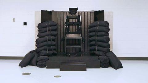 Ein Stuhl für die Vollstreckung der Todesstrafe durch Erschießen. Im Stuhl sind vier Einschusslöcher sichtbar.