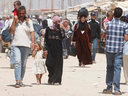 Syrische Flüchtlinge laufen im September 2013 über die Hauptstraße eines Flüchtlingscamps in Mafraq, Jordanien.