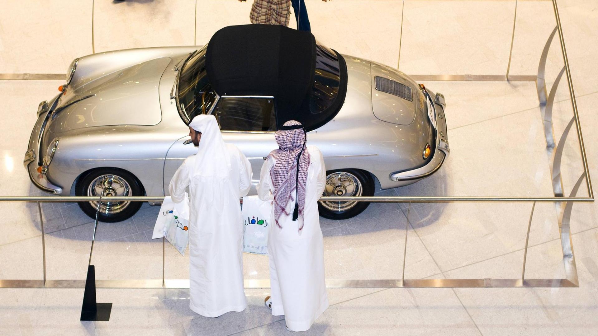 Zwei Scheichs vor einem alten Porsche in einem Einkaufszentrum in Dubai Zwei Scheichs vor einem alten Porsche in einem Einkaufszentrum in Dubai