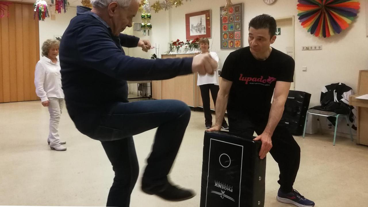 Der Teilnehmer des Kurse tritt in eine Box, die der Trainer hält. Der Teilnehmer des Kurse tritt in eine Box, die der Trainer hält.