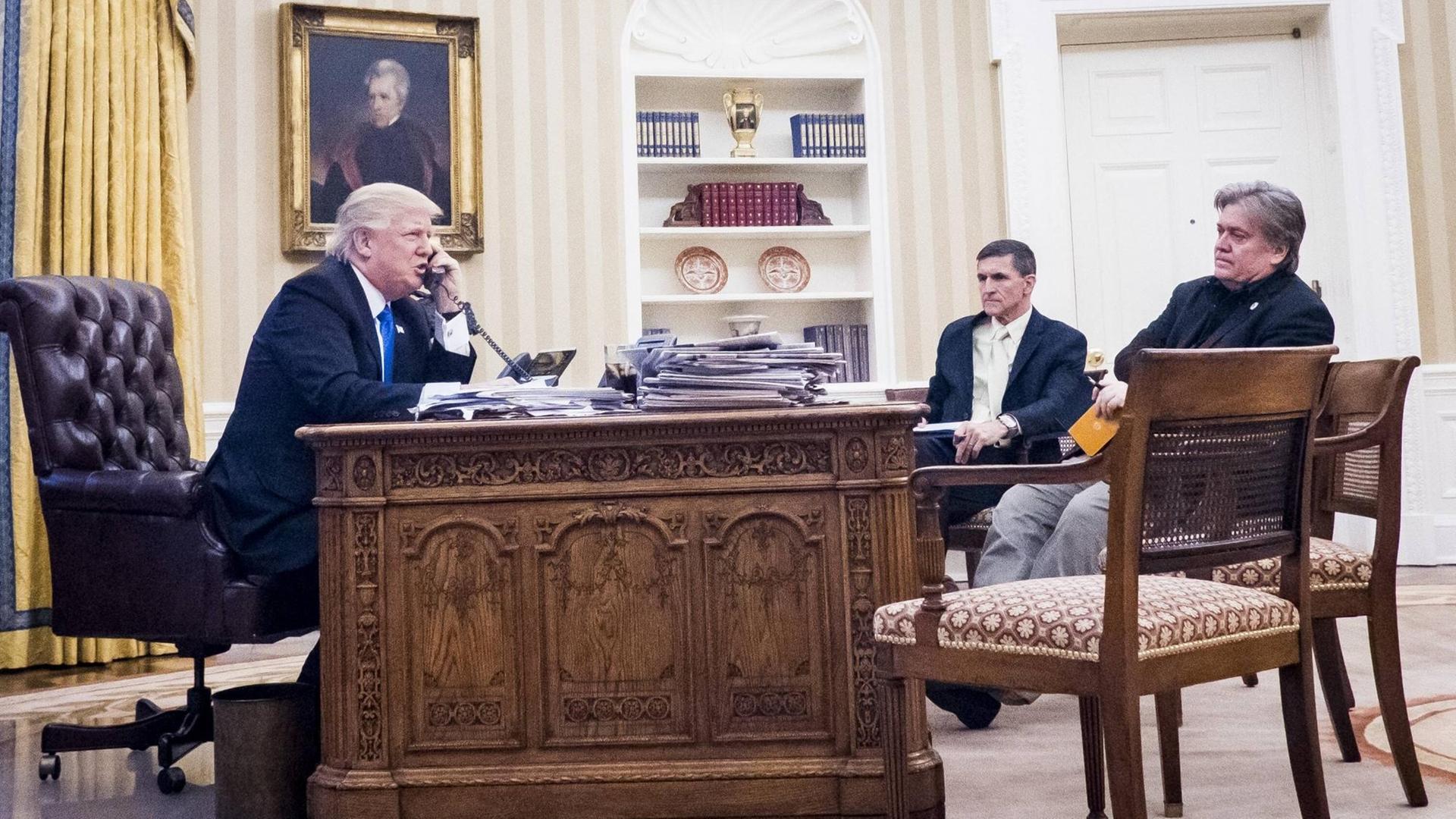US-Präsident Donald Trump mit dem Nationalen Sicherheitsberater Michael Flynn and Chefberater Steve Bannon im Oval Office im Weißen Haus, Washington. Trump telefoniert mit dem australischen Premier Malcolm Turnbull am 28.1.2017.