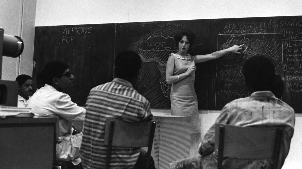 Die Dozentin Toni Maraini steht vor einer Tafel und unterrichtet in den 60er Jahren ihre Kunstgeschichtsklasse an der Ecole des Beaux-Arts in Casablanca, Marokko. Das Bild stammt aus einer pädagogischen Broschüre der Ecole de Casablanca, 1962-1965. Die Dozentin Toni Maraini steht vor einer Tafel und unterrichtet in den 60er Jahren ihre Kunstgeschichtsklasse an der Ecole des Beaux-Arts in Casablanca, Marokko. Das Bild stammt aus einer pädagogischen Broschüre der Ecole de Casablanca, 1962-1965.