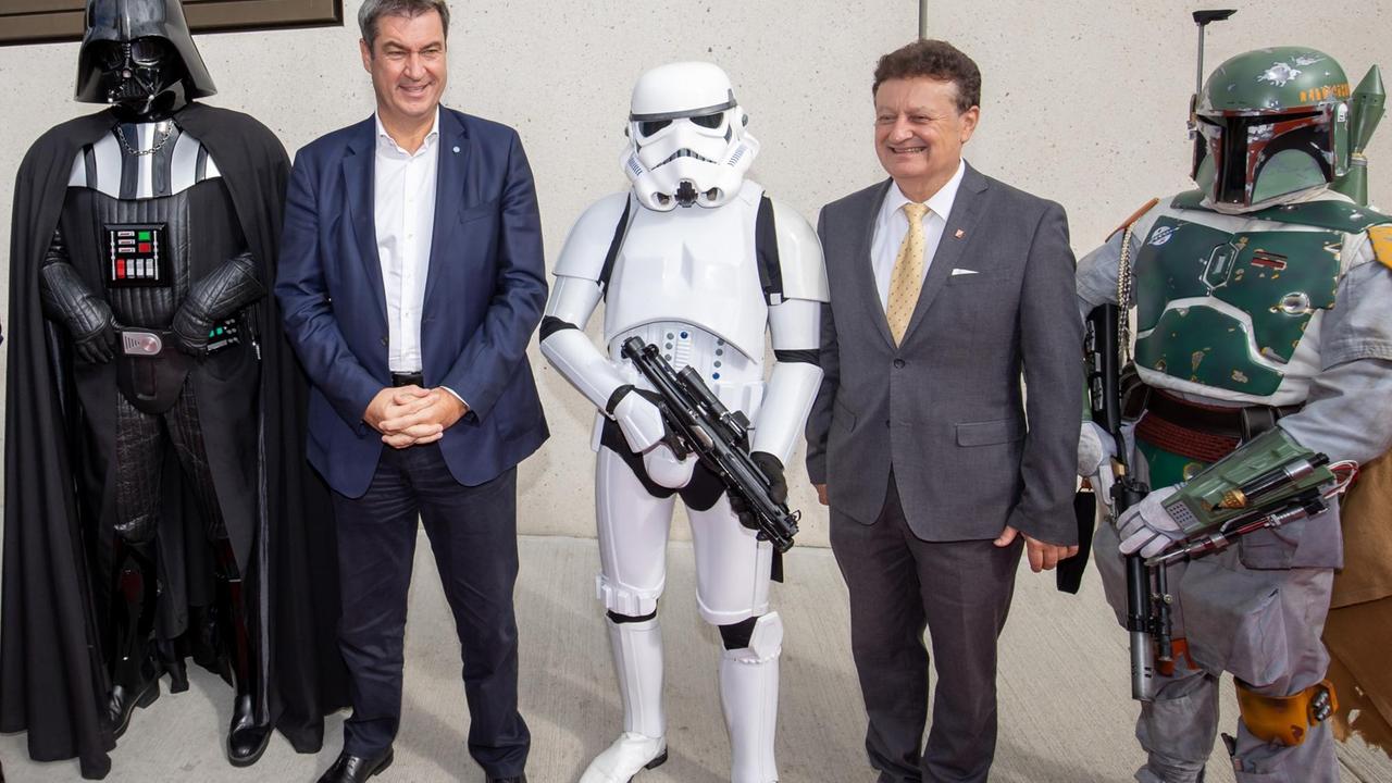 Der Bayerische Ministerpräsident Markus Söder und Wolfgang Heckl, Generaldirektor des Deutsches Museums, stehen zwischen Figuren aus der Filmreihe "Star Wars" – im Rahmen der Eröffnung der neuen Zweigstelle des Deutschen Museums in Nürnberg.