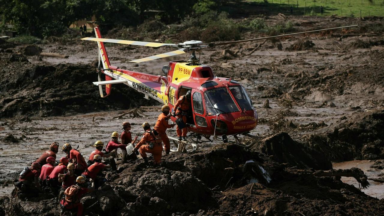 Mit einem Rettungshubschrauber wird versucht, noch Überlebende aus dem Schlamm in der zerstörten Eisenerzmine in Brumadinho zu borgen. Mit einem Rettungshubschrauber wird versucht, noch Überlebende aus dem Schlamm in der zerstörten Eisenerzmine in Brumadinho zu borgen.