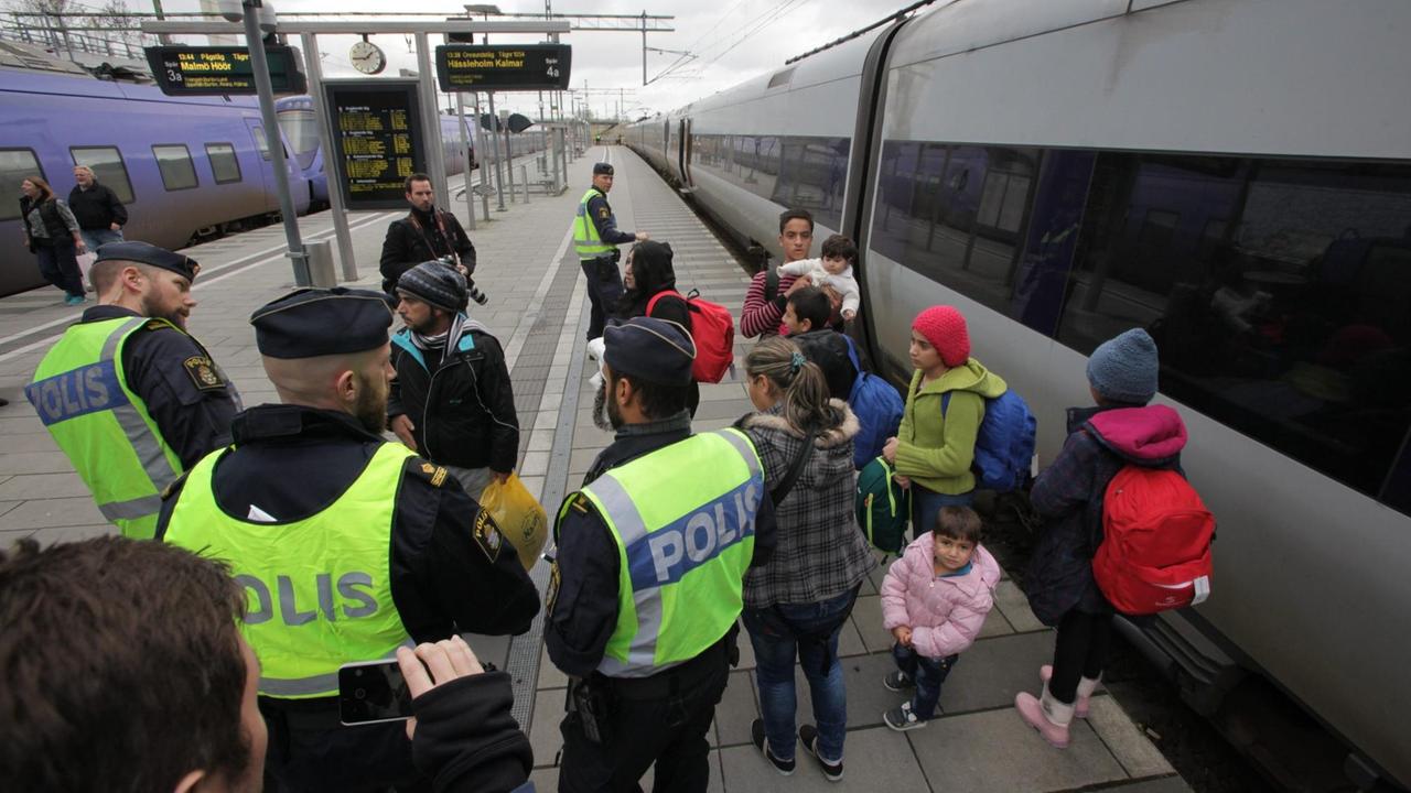 Schwedische Polizisten mit Flüchtlingen. 