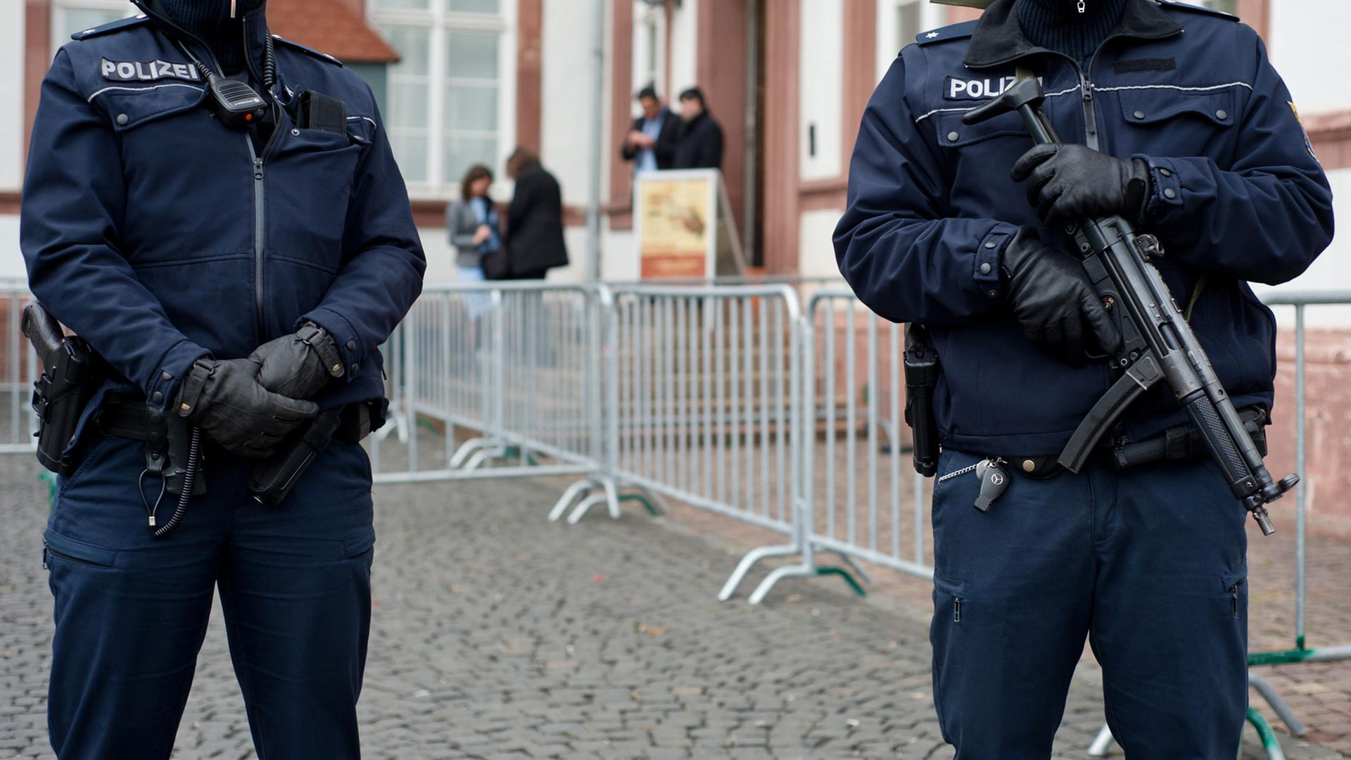Schwerbewaffnete Polizisten stehen am 14.03.2015 vor dem Eingang der Karikaturen-Ausstellung "Das ist ja wohl ein Witz!" im hessischen Hanau. Schwerbewaffnete Polizisten stehen am 14.03.2015 vor dem Eingang der Karikaturen-Ausstellung "Das ist ja wohl ein Witz!" im hessischen Hanau.