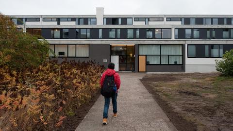 Ein Student geht zu Haus Neun des Studentendorfs Schlachtensee in Berlin. Das Haus wurde renoviert.