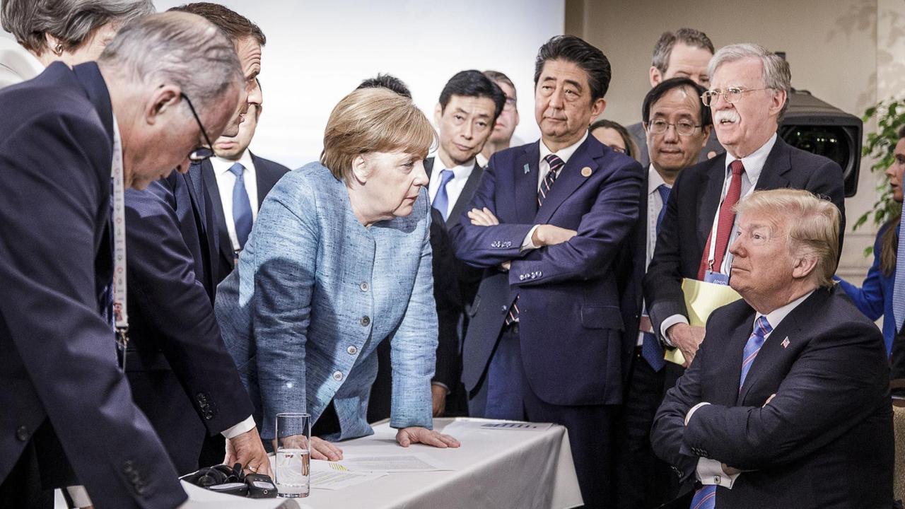 Merkel spricht mit Trump während Macron, Abe und Bolton zuhören. Merkel spricht mit Trump während Macron, Abe und Bolton zuhören.